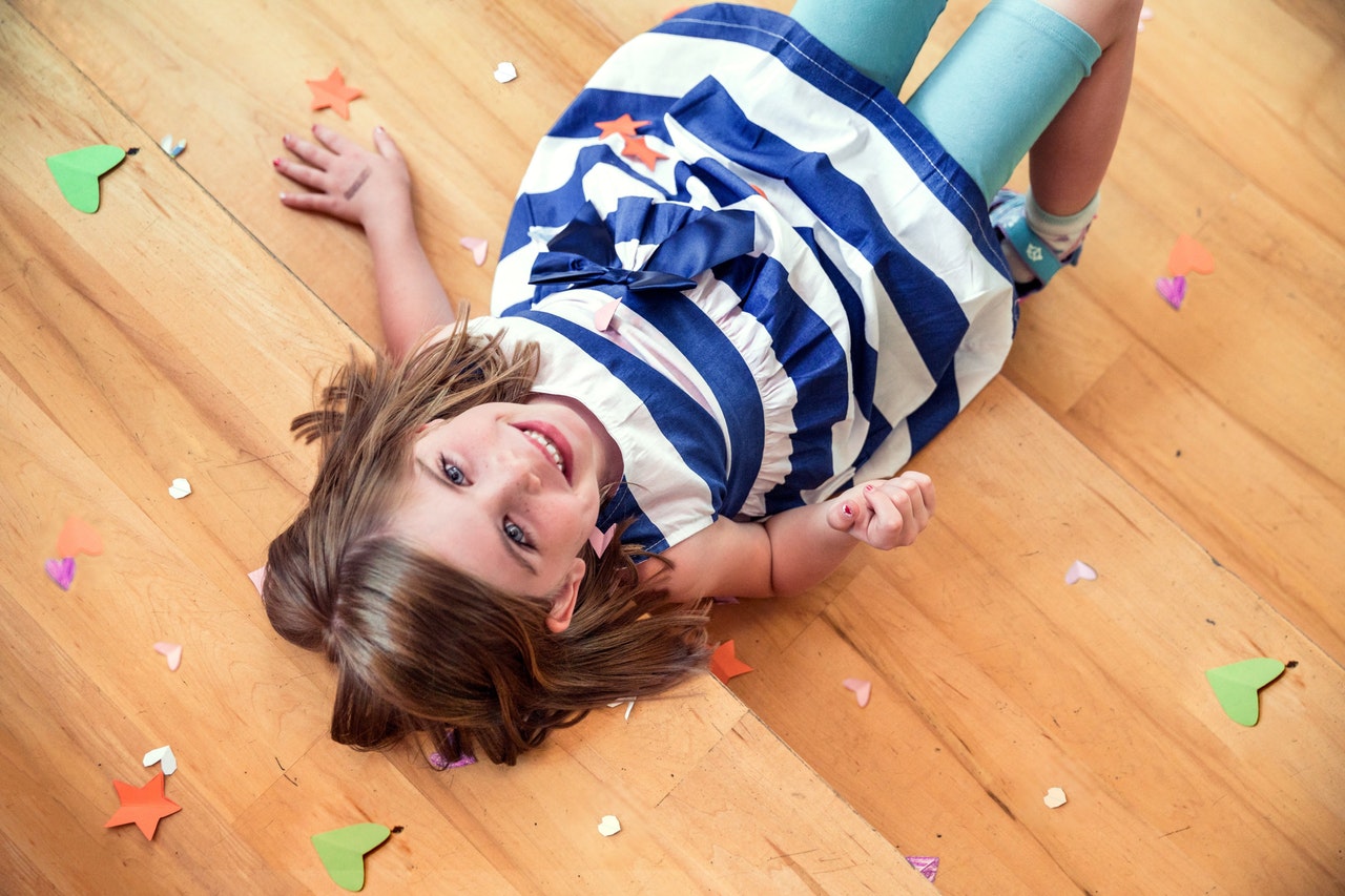 child lying down on a hardwood floor which is one of the best types of flooring