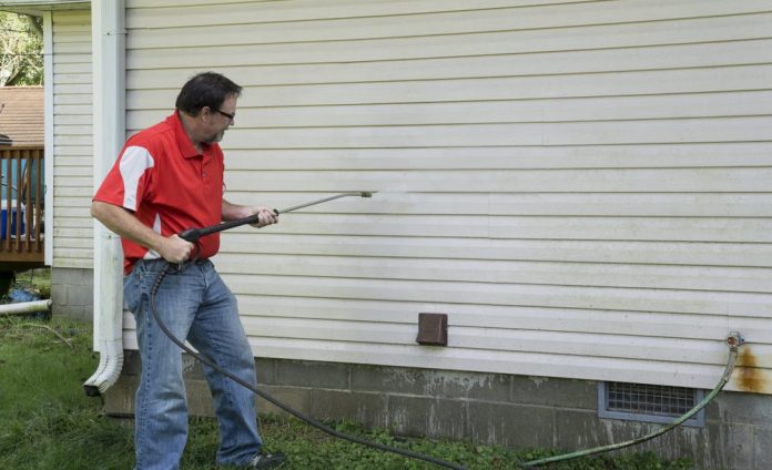 man using a pressure washer