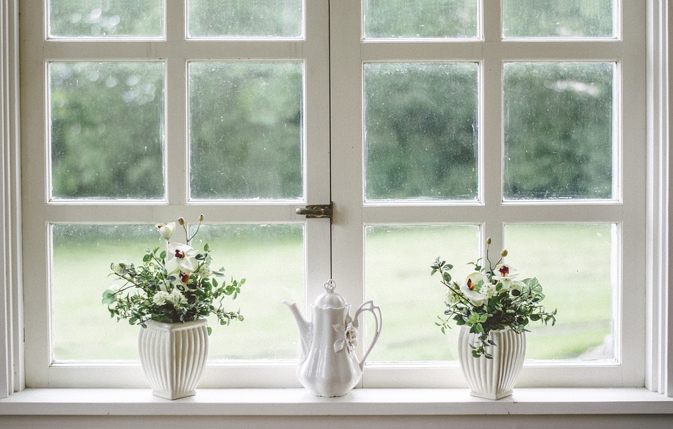 White teapot and tow flower vases on windowpane