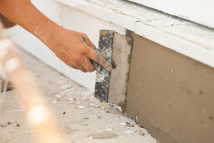 man doing finishing work for a house foundation